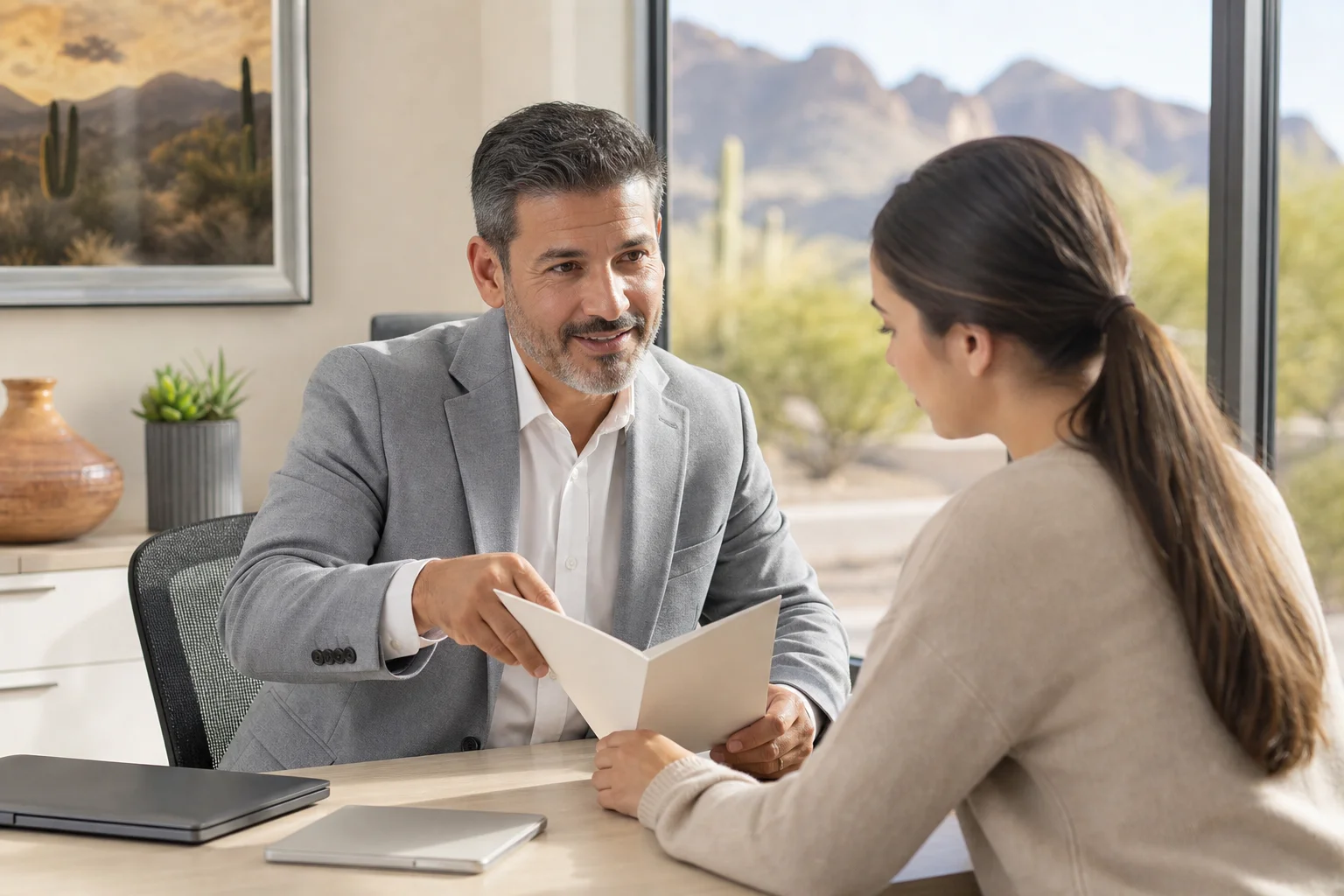 Health insurance advisor helping a young adult review coverage options after turning 26 in Arizona